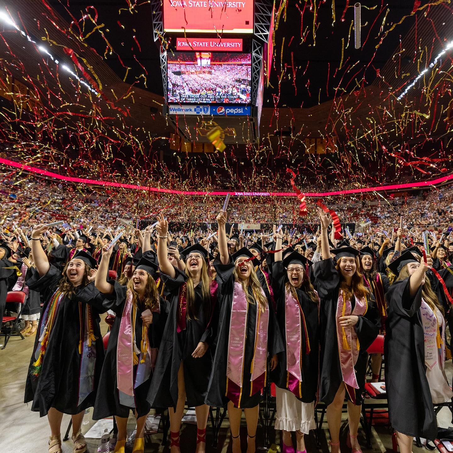 students graduating and sending confetti in the air