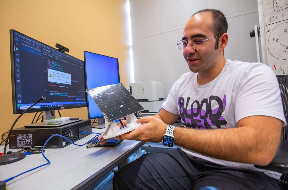 Graduate student demonstrating a tool